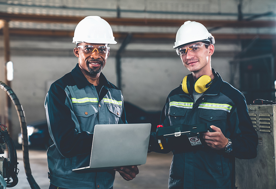 Two Factory Workers Using Adept Machine Equipment In A Workshop